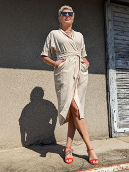 Kremowa sukienka z wąską talią, prostym dołem i kopertowym fasonem na modelu Iza